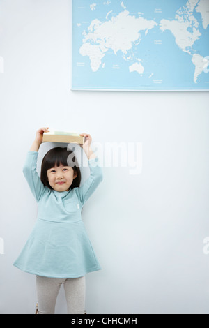 Preschooler girl with books on the head Stock Photo - Alamy