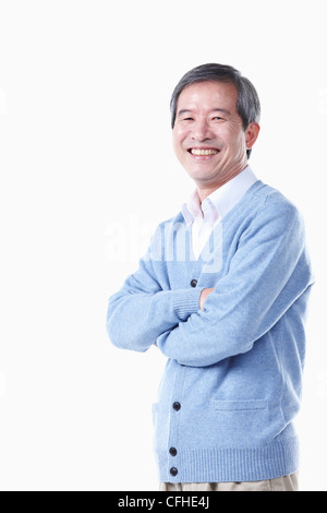 A standing elderly man with his arms folded Stock Photo
