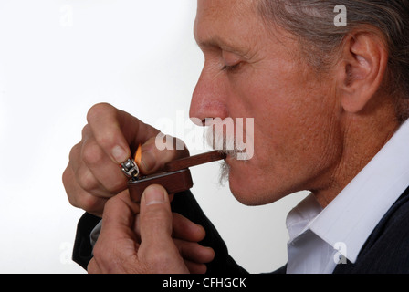 Middle aged man smoking from a marijuana pipe Stock Photo