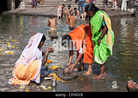 Indian women worshiping a Shiva lingam. Godavari river. Nasik. India ...