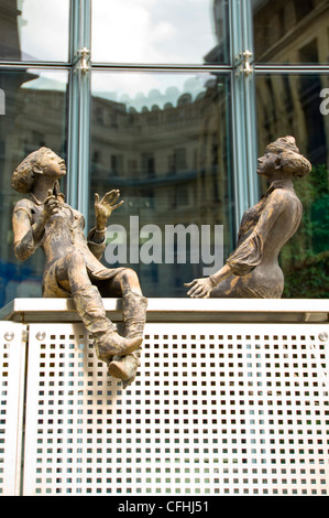 Vertical close up of bronze sculptures of people sitting outside the Charlemagne Building in central Brussels, Belgium Stock Photo