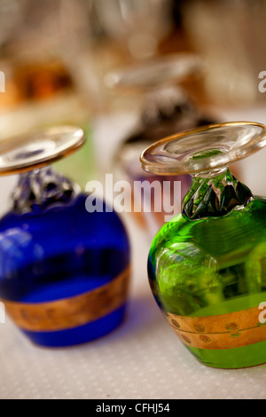 Hand blown, brightly colored, crystal brandy snifters with gold leaf stripes Stock Photo
