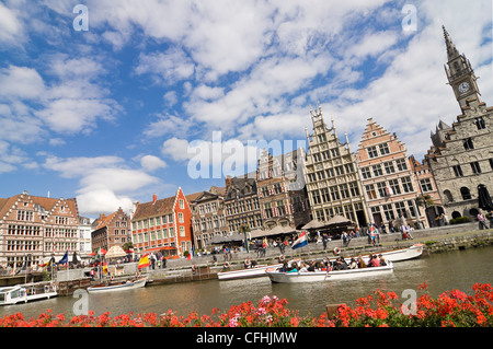 Horizontal view of old architecture on Graslei, Tussen Bruggen, with boats sailing passed on the river Leie in Ghent, Belgium Stock Photo