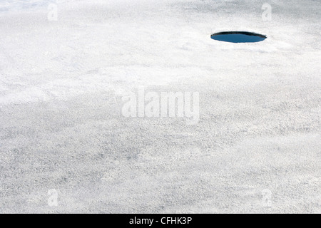 A small hole in thin ice. Stock Photo