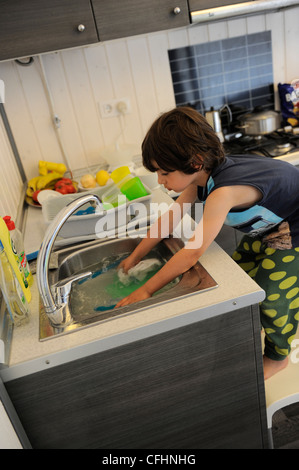 Boy doing the dishes Stock Photo