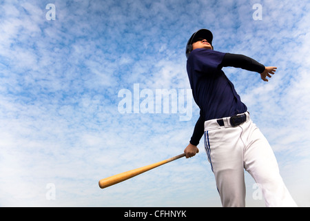 baseball player taking a swing with cloud background Stock Photo