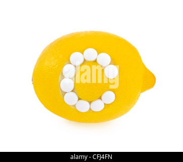 Lemon with vitamin c pills over white background - isolated - health concept Stock Photo