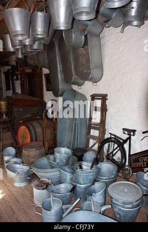 old grocery delivery bike in hardware shop with old fashioned tin ware,tin bath,tin buckets and pail's, Stock Photo