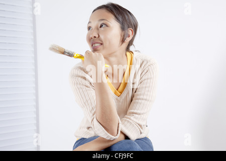 Young woman holding a painting brush Stock Photo