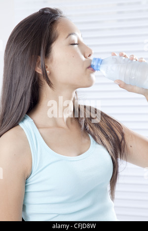 Young woman drinking bottled water Stock Photo