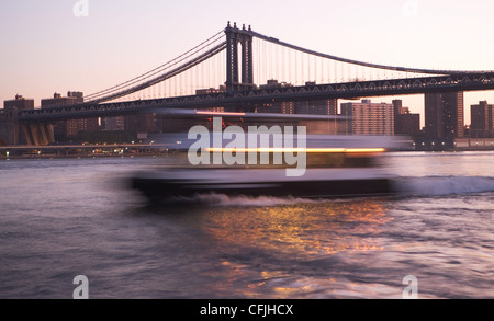 Boat in motion on East River by Manhattan Bridge, New York City, USA Stock Photo