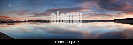 Panorama of moonrise and sunset over Findhorn Bay on the Moray Firth Stock Photo