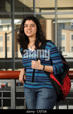 Young Eastern Student holding her backpack with College Campus buildings as background Stock Photo