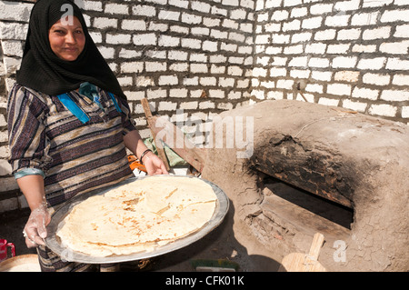 Woman with just made traditional Aich bread Minya Egypt Stock Photo