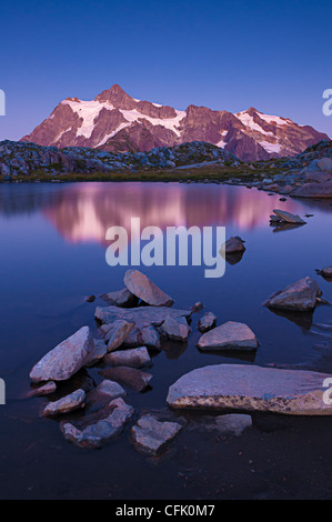 Mount Shuksan and reflection in tarn on Artist Ridge at dusk; Mount Baker-Snoqualmie National Forest, Washington. Stock Photo