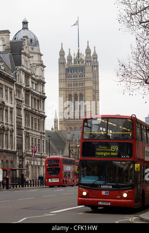 London Bus traveling past 10 downing street with Big Ben in the background Stock Photo