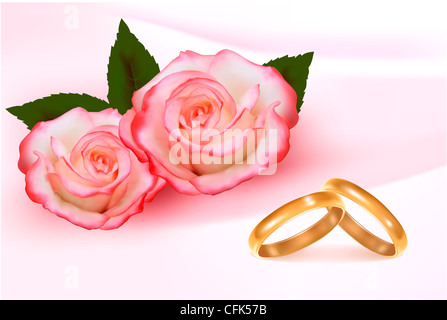 Gold wedding rings in front of two pink roses Stock Photo