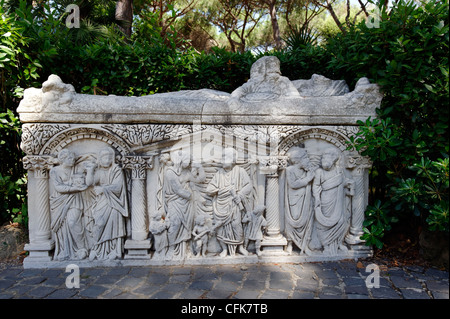 Ostia Antica. Lazio. Italy. View of an ornate marble sarcophagus with three intricate human figure scenes separated by columns. Stock Photo