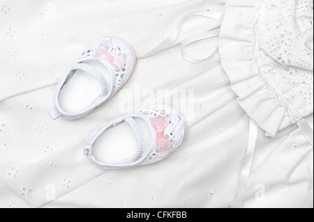 A new set of baby shoes on a white dress Stock Photo