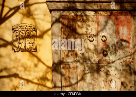 Vintage yellow wall with wooden doors and wrought iron window in upscale neighborhood Santana Row, California. Stock Photo