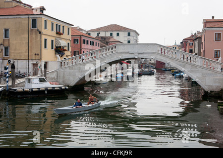 Boat traveling through the canals of Chioggia, Venice, Veneto, Italy Stock Photo