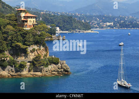 Yacht sailing along coastline of Portofino on Ligurian sea, Northern Italy. Stock Photo