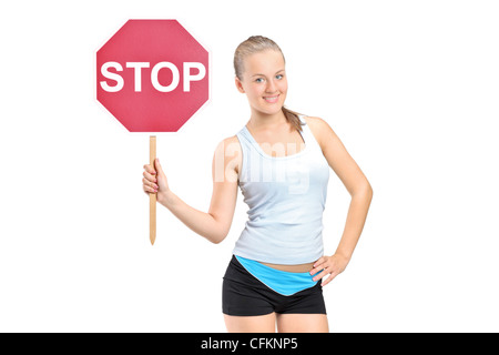 A smiling girl holding a traffic sign stop isolated on white background Stock Photo