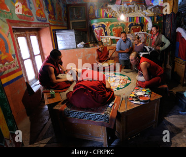 Tourists watch buddhist monks preparing a mandala using powdered pigments. Stock Photo