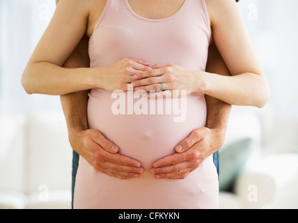 USA, New Jersey, Jersey City, Midsection of man hugging pregnant woman Stock Photo