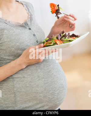 USA, New Jersey, Jersey City, Midsection of pregnant woman eating salad Stock Photo