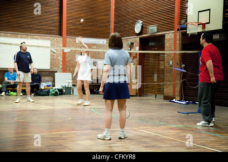 People playing a game of doubles badminton at their local club, Newmarket Suffolk UK Stock Photo