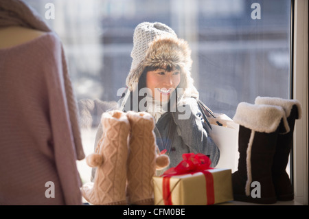 USA, New Jersey, Jersey City, Smiling woman looking at shop display during Christmas shopping Stock Photo