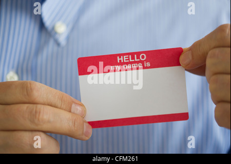 Jersey City, New Jersey, Close up of businessman's hands holding blank name tag, studio shot Stock Photo