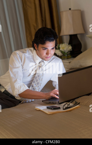 USA, New Jersey, Jersey City, Businessman working on laptop in hotel room Stock Photo