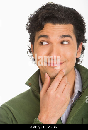 Studio shot of young man looking surprised and happy Stock Photo
