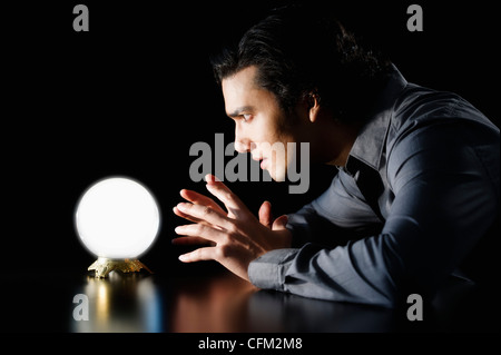 Studio shot of businessman staring at crystal ball Stock Photo