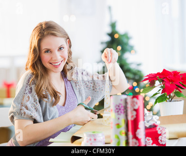USA, New Jersey, Jersey City, Portrait of young woman wrapping Christmas gifts Stock Photo