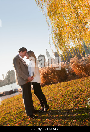 USA, New York, Long Island City, Young couple standing in park Stock Photo