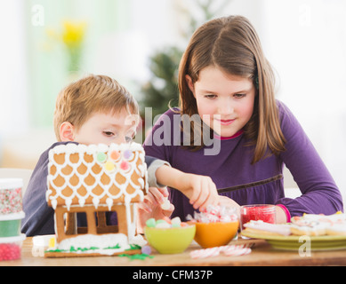 USA, New Jersey, Jersey City, Girl (8-9) and boy (6-7) preparing gingerbread decorations Stock Photo