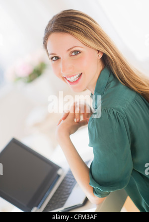 USA, New Jersey, Jersey City, Portrait of young woman working with laptop Stock Photo