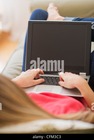 USA, New Jersey, Jersey City, Portrait of young woman with laptop in living room Stock Photo