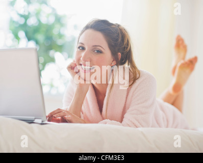 USA, New Jersey, Jersey City, Portrait of young woman with laptop in bedroom Stock Photo
