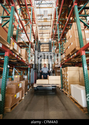 USA, California, Santa Ana, Forklift truck stacking boxes in warehouse Stock Photo