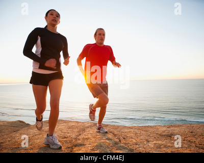 USA, California, San Diego, Man and woman jogging along sea coast Stock Photo