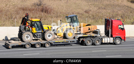 Lorry and low loader trailer carrying heavy civil engineering plant including JCB 3170 Stock Photo