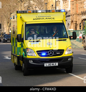 NHS London UK ambulance emergency SOS call National Health Service paramedic crew on board responding 999 call driving & speeding blue flashing light Stock Photo