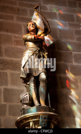 Statue of St. Joan of Arc with coloured light from stained glass, Church of Notre Dame, Vitre, Brittany, France, Europe Stock Photo