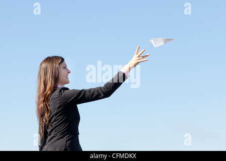 USA, Seattle, Smiling businesswoman throwing paper plane Stock Photo