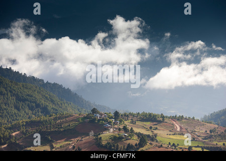 Village of Shingyer against a dramatic backdrop of mountains and clouds, Phobjikha Valley, Bhutan, Himalayas, Asia Stock Photo