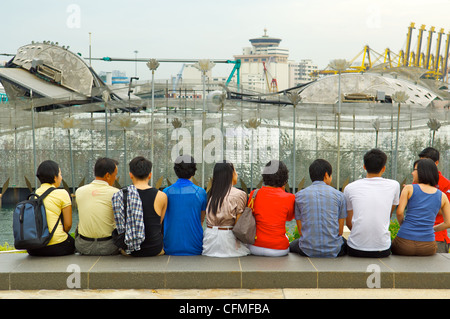Group of people sitting with their backs to the camera, Sentosa, Singapore Stock Photo